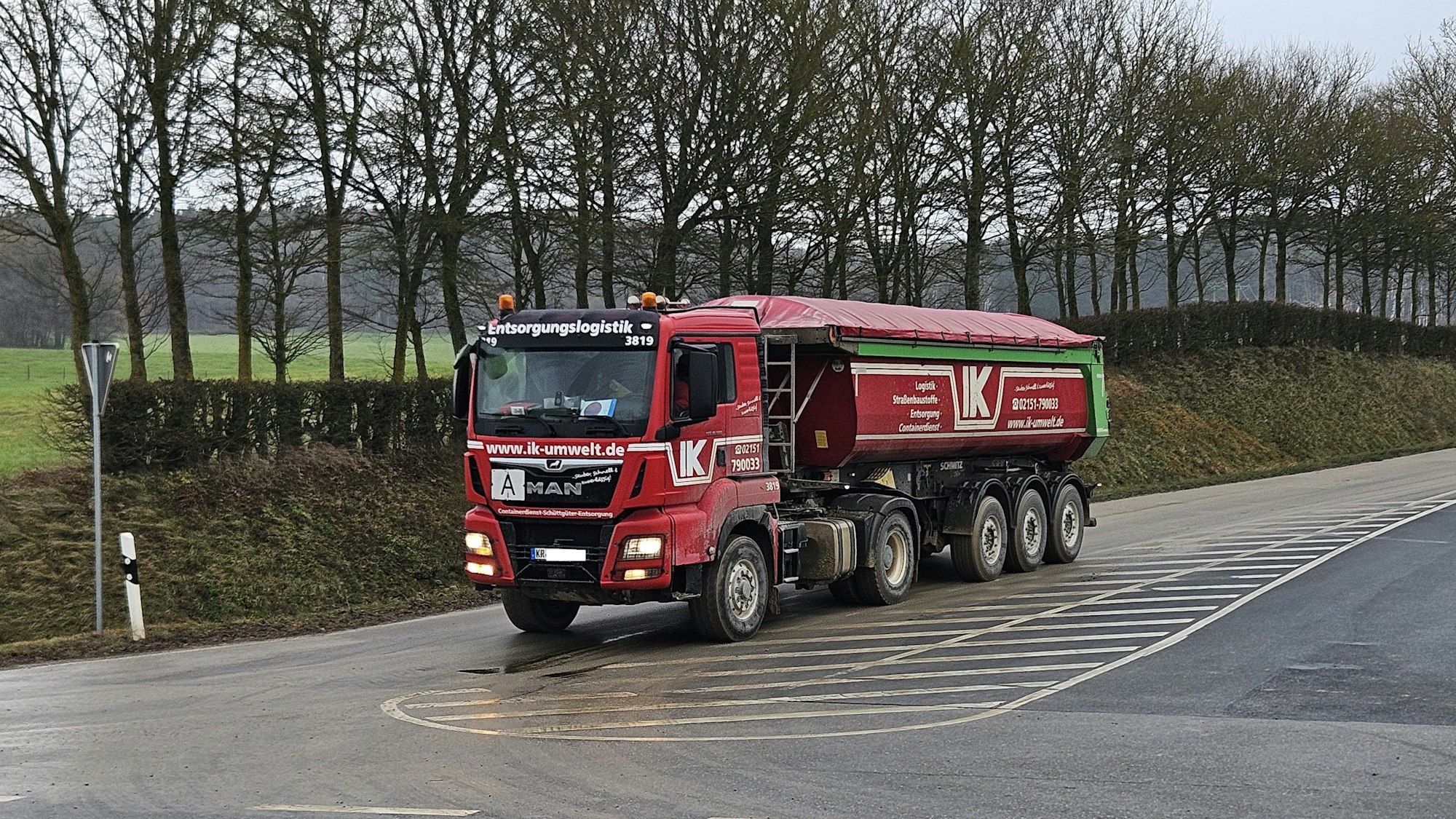 Ein Lastwagen fährt über eine verschmutzte Straße.