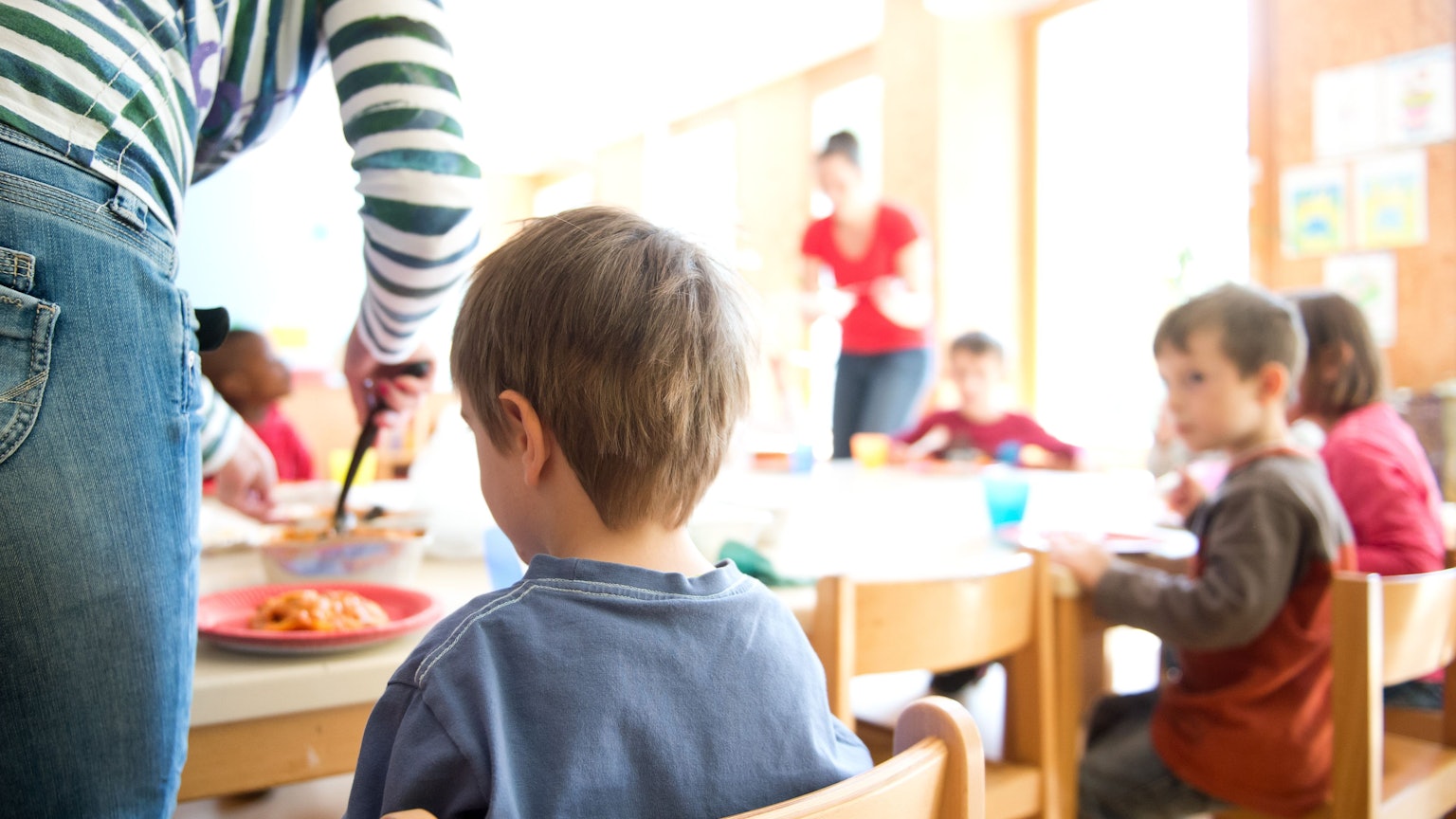 Eine Erzieherin serviert Kindern Lasagne zum Mittagessen in einer Kindertagesstätte. (Archivbild)