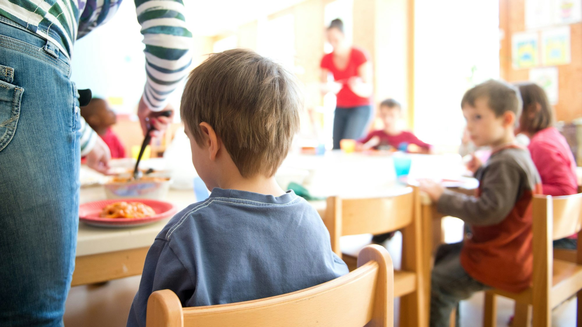 Eine Erzieherin serviert Kindern Lasagne zum Mittagessen in einer Kindertagesstätte. (Archivbild)