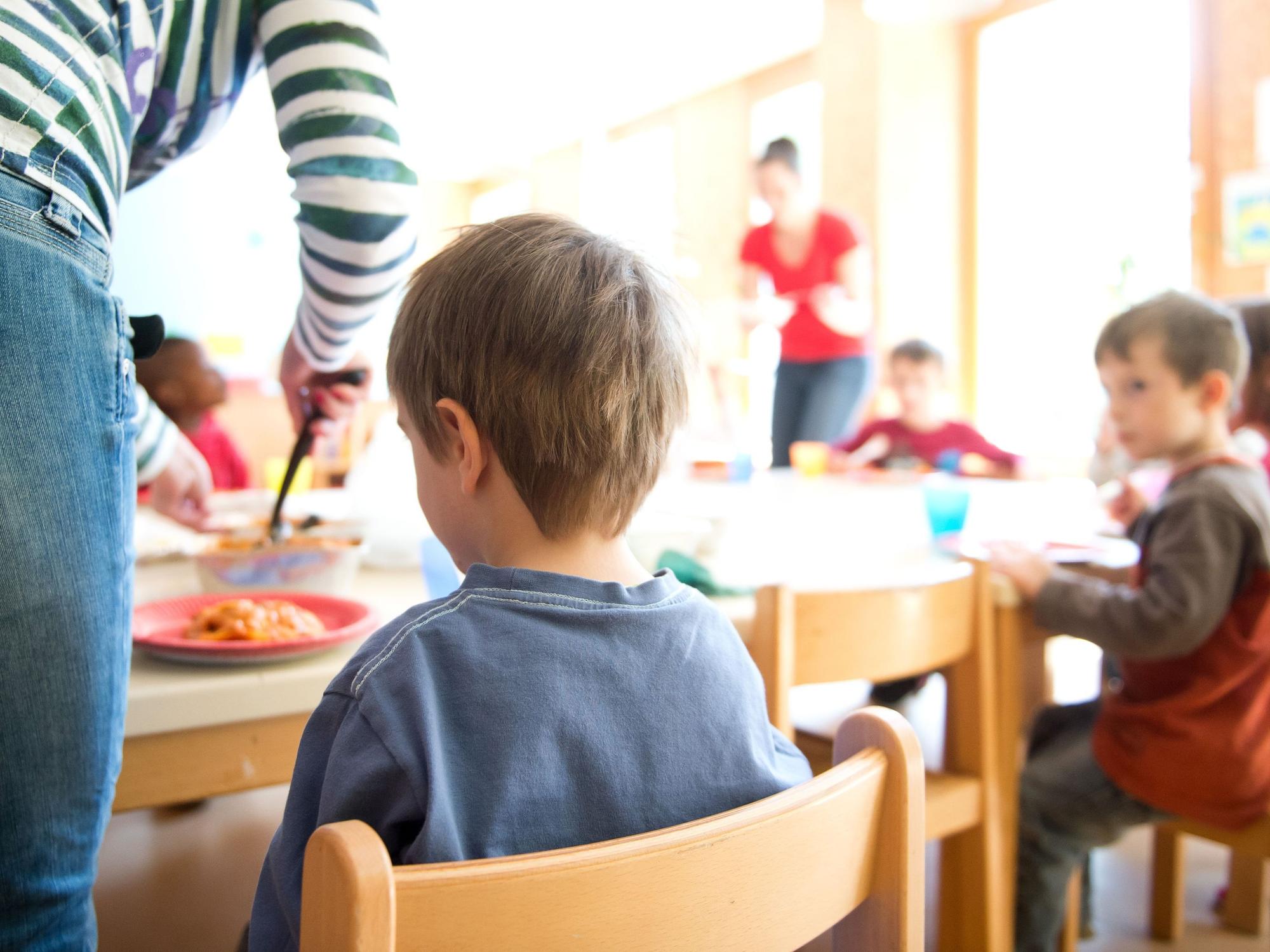 Eine Mutter serviert Kindern Lasagne zum Mittagessen in Stuttgart in einer Kindertagesstätte.