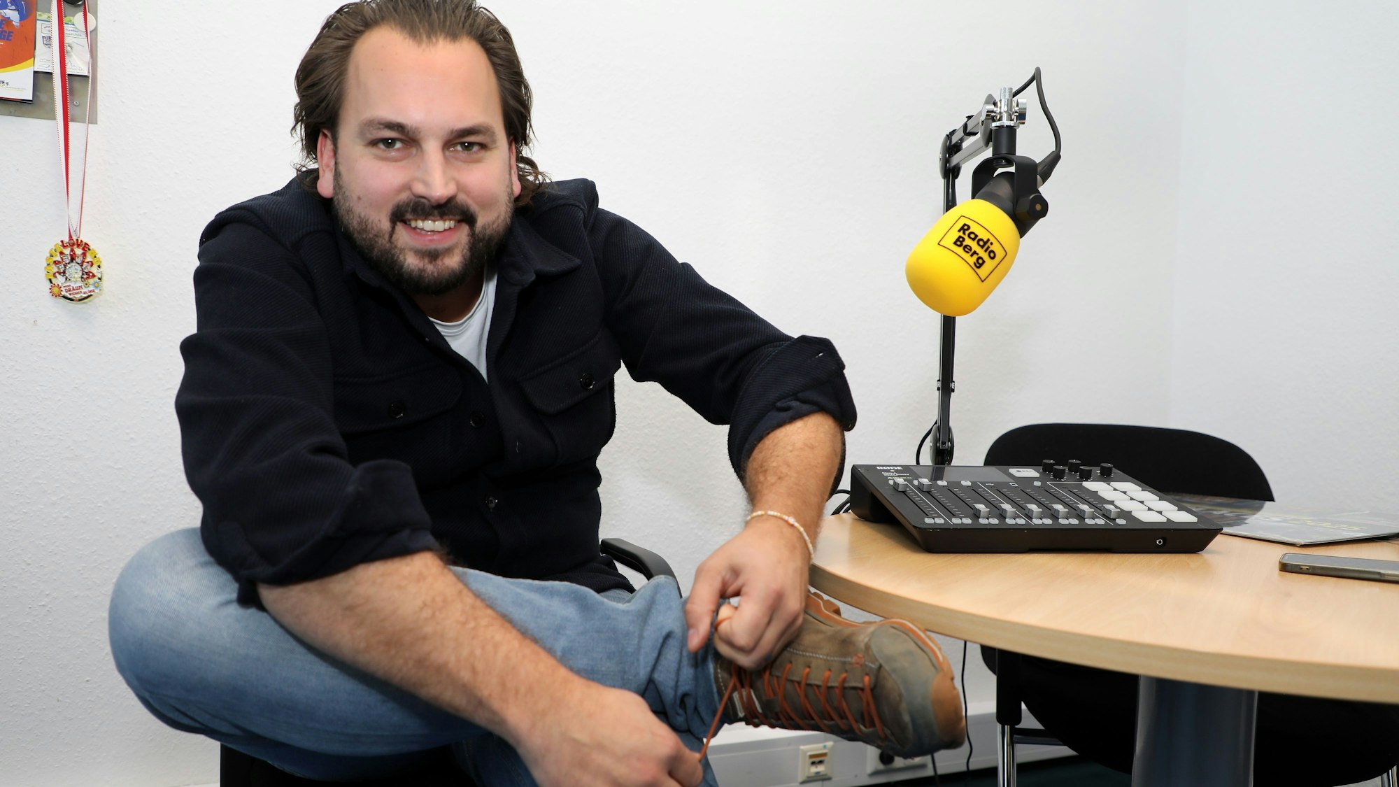 Radiomoderator Markus Hendrich schnürt im Radio-Berg-Studio die Wanderschuhe.