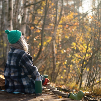 Serene woman backpacker meditating on eco trail, watching natural landscape in sunny fall woods Rearview of serene woman backpacker meditating on eco trail, watching natural landscape in sunny fall woodland. Calm female enjoy autumn air, basking in sun, drinking hot thermos tea in park ,model released, Symbolfoto Copyright: xZoonar.com/DmitriixMarchenkox 22150530 ,model released, Symbolfoto ,property released