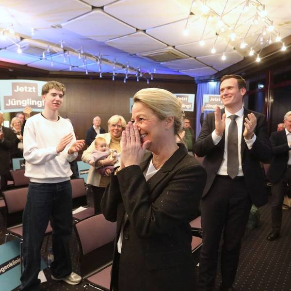 Mehrere Menschen applaudieren einer Frau, teilweise halten sie Schilder mit der Aufschrift „Jetzt Jüngling“ in die Höhe.