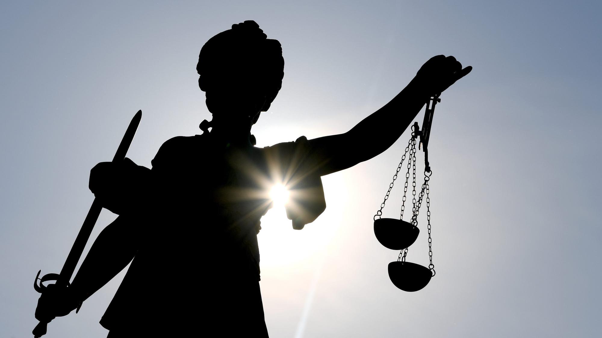 25.02.2019, Hessen, Darmstadt: Die Göttin Justitia im Gegenlicht auf dem Gerechtigkeitsbrunnen in Frankfurt am Main.