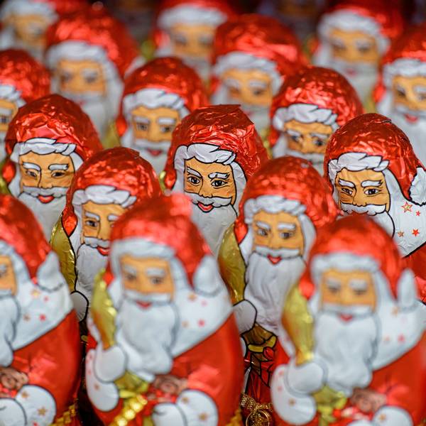 Weihnachtsmänner aus Schokolade stehen in einem Supermarkt-Regal.