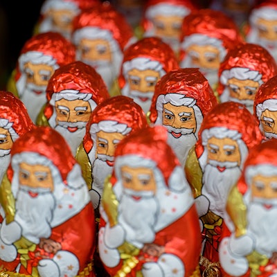 Weihnachtsmänner aus Schokolade stehen in einem Supermarkt-Regal.