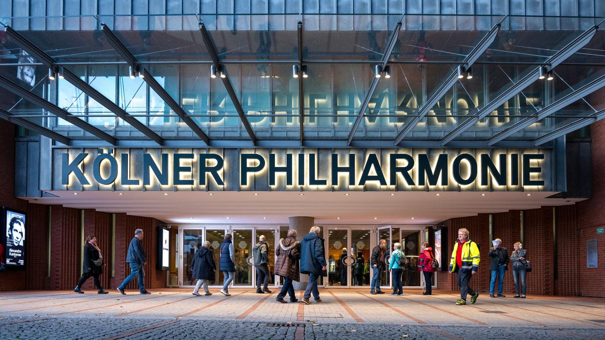 Menschen gehen in die Kölner Philharmonie.