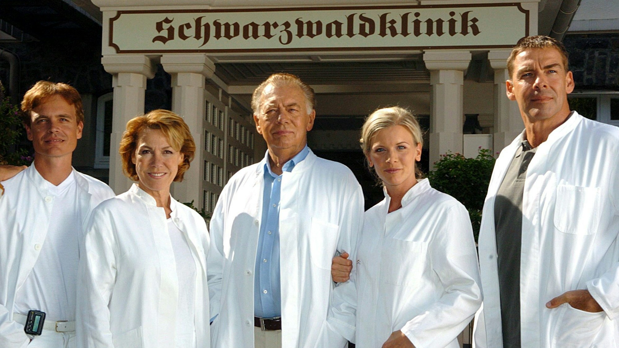 Auf dem Foto sind Schauspieler in weißen Arztkitteln zu sehen.