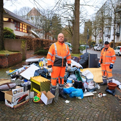 Illegal entsorgter Müll mitten in der Kölner Südstadt. Die AWB-Männer Georg Happe (l.) und Olaf Jablonski laden pro Tag viele solcher Haufen ein.