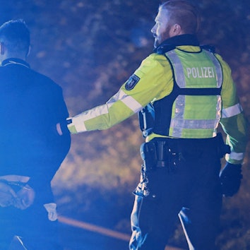 Polizisten nehmen einen Lastwagenfahrer auf der Autobahn 1 bei Hagen in Gewahrsam.