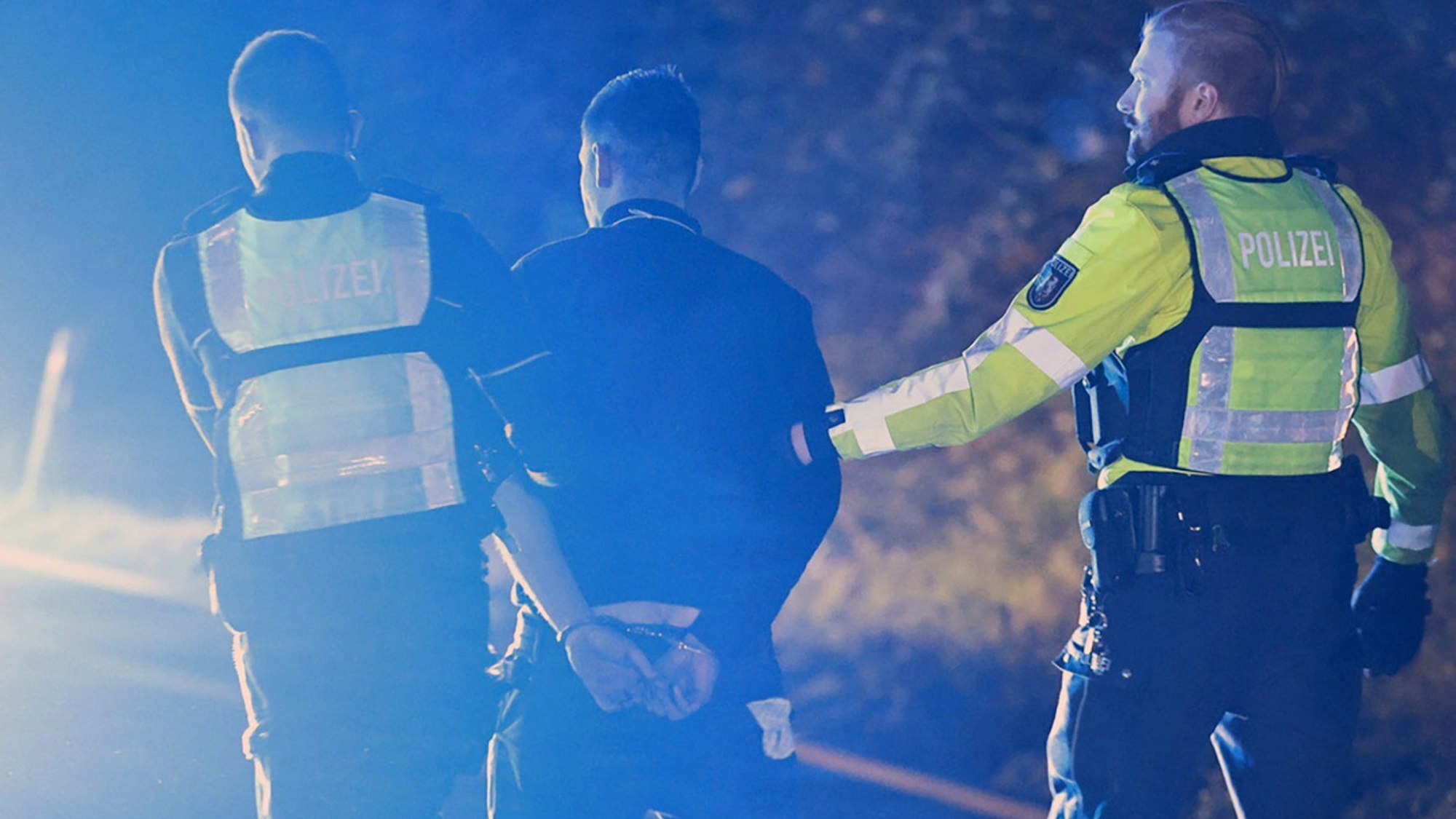Polizisten nehmen einen Lastwagenfahrer auf der Autobahn 1 bei Hagen in Gewahrsam.