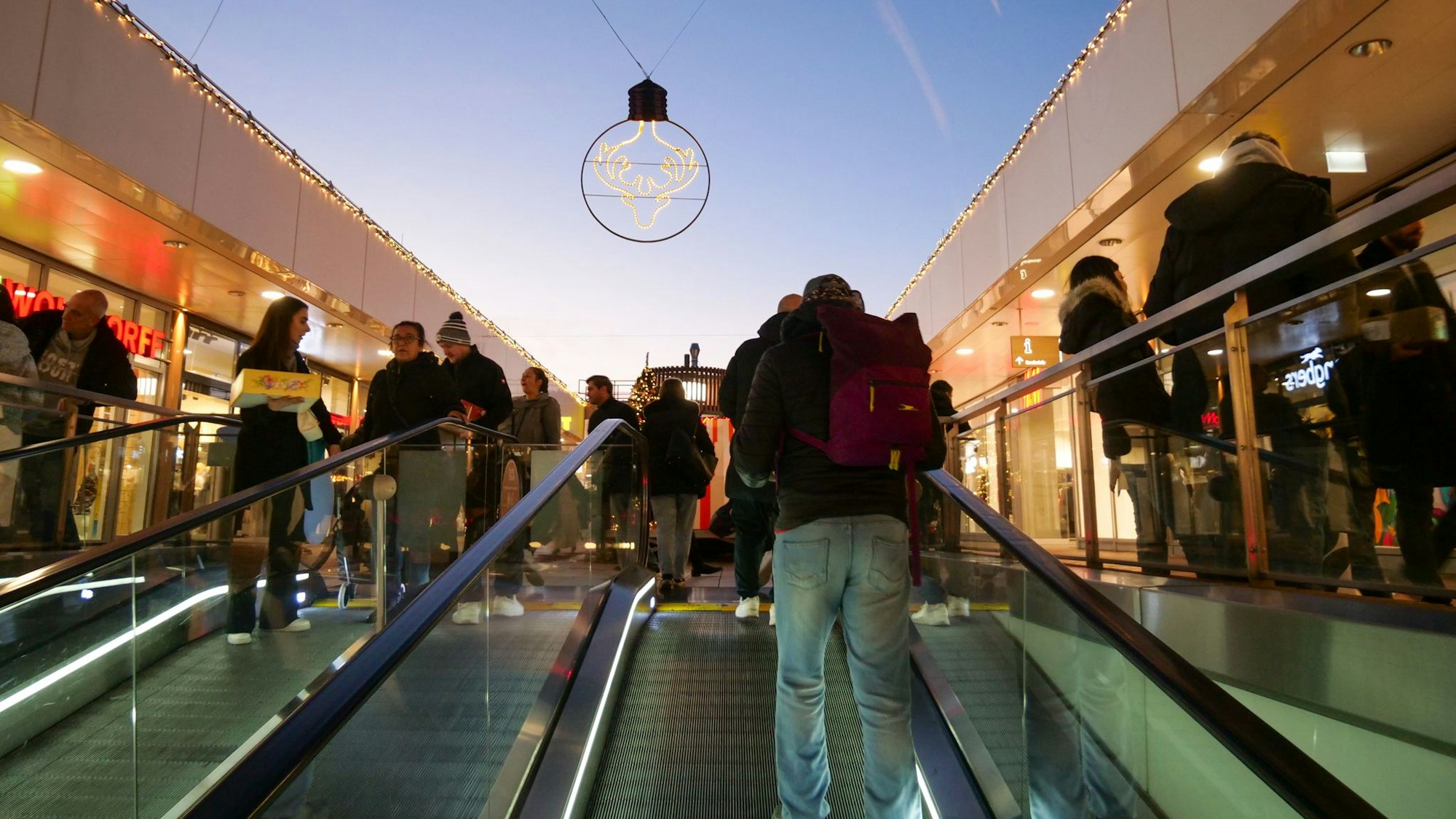 Menschen fahren auf einer Rolltreppe.