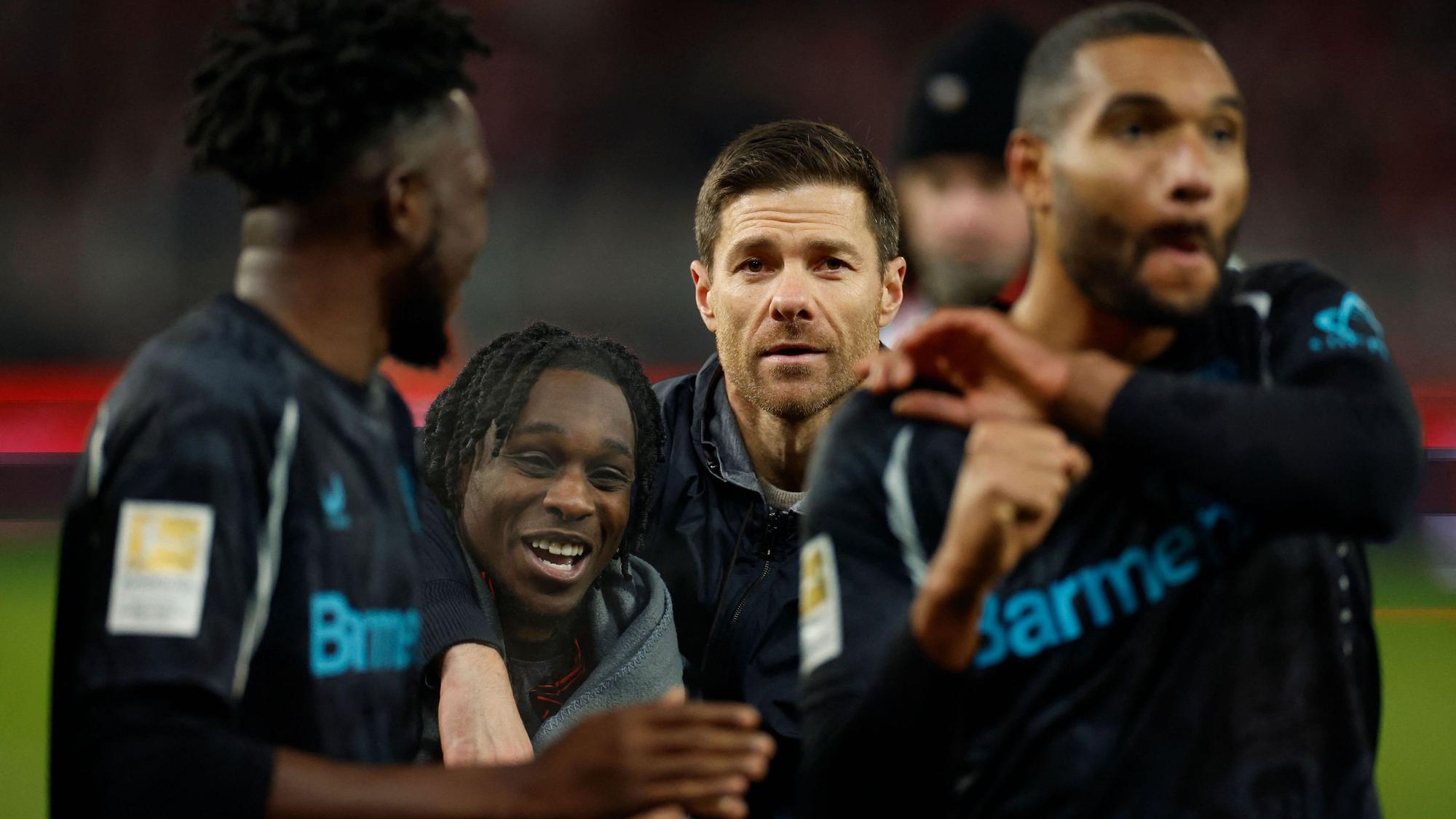 Leverkusens Trainer Xabi Alonso mit Edmond Tapsoba (v.l.), Jeremie Frimpong und Jonathan Tah nach dem Sieg in Berlin.