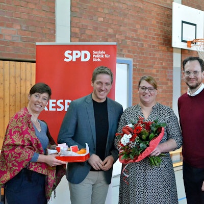 Annegret Lewak, Markus Rahmers, Andrea Kanonenberg, Thilo Waasem und Helge Herrwegen (v.l.n.r.) haben sich vor einem SPD-Roll-up zum Gruppenbild aufgestellt. Kanonenberg hält einen großen Blumenstrauß in Händen.