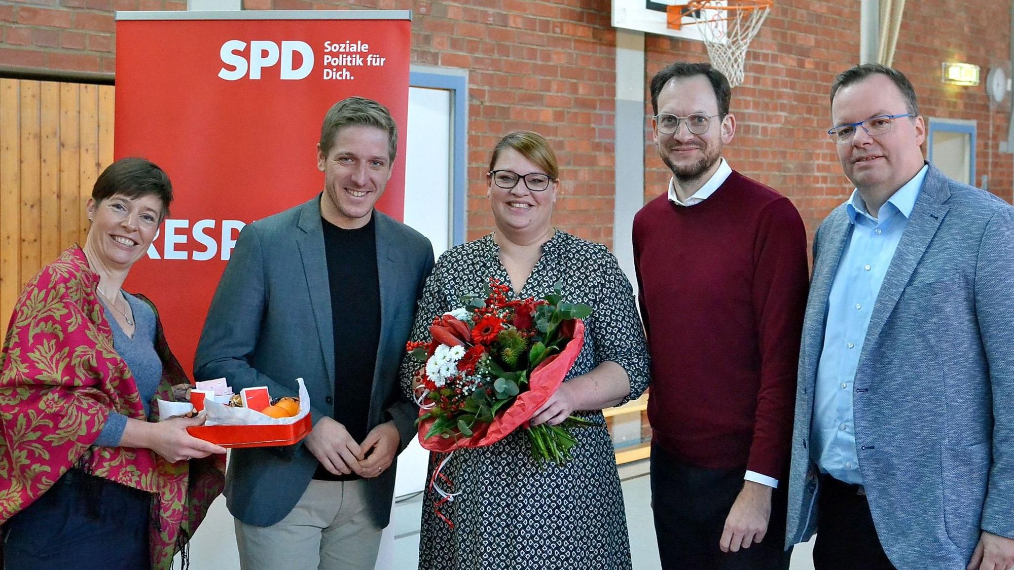 Annegret Lewak, Markus Rahmers, Andrea Kanonenberg, Thilo Waasem und Helge Herrwegen (v.l.n.r.) haben sich vor einem SPD-Roll-up zum Gruppenbild aufgestellt. Kanonenberg hält einen großen Blumenstrauß in Händen.