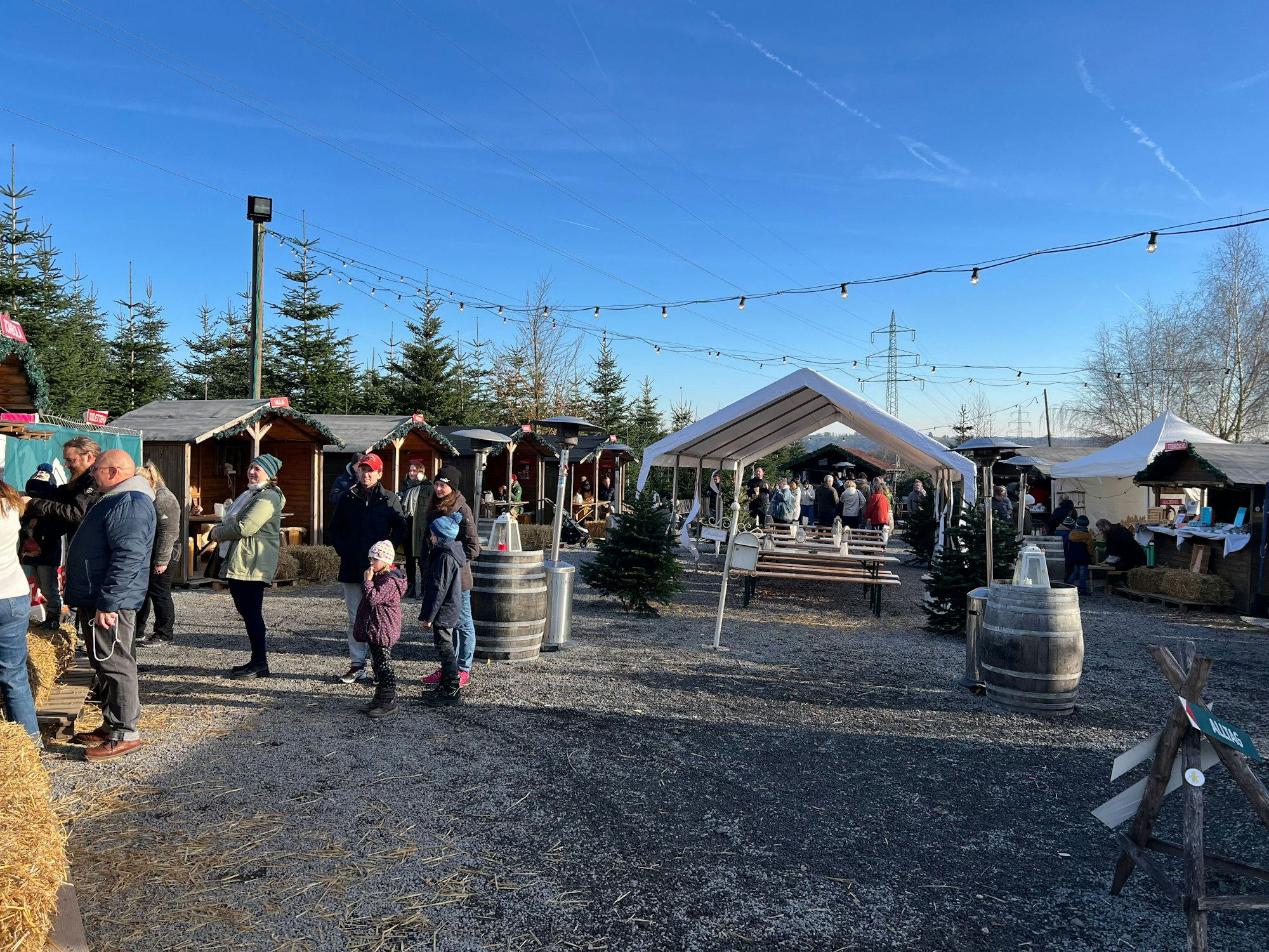 Menschen stehen zwischen Marktbuden.