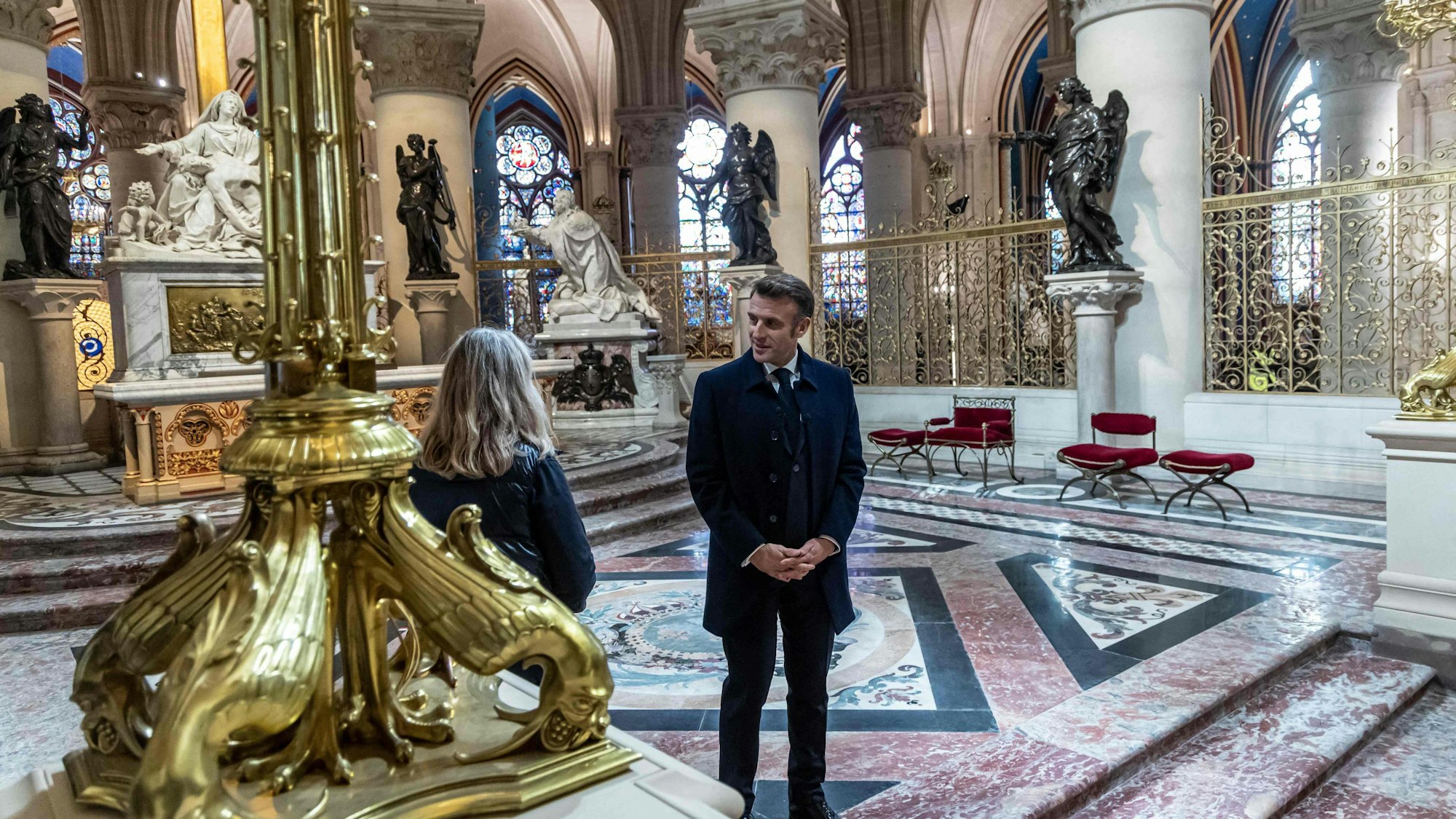 French President Emmanuel Macron (R) speaks with an art restorer during his visit at the Notre-Dame de Paris Cathedral in Paris, on November 29, 2024.
