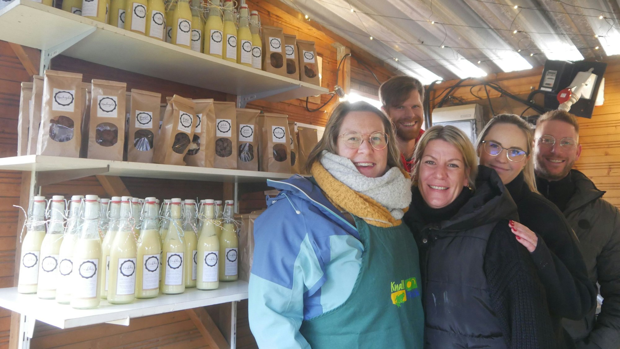 Männer und Frauen stehen in einer Verkaufsbude.