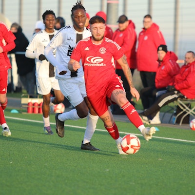 Nico Berekoven führt den Ball, ein Gegenspieler verfolgt ihn.