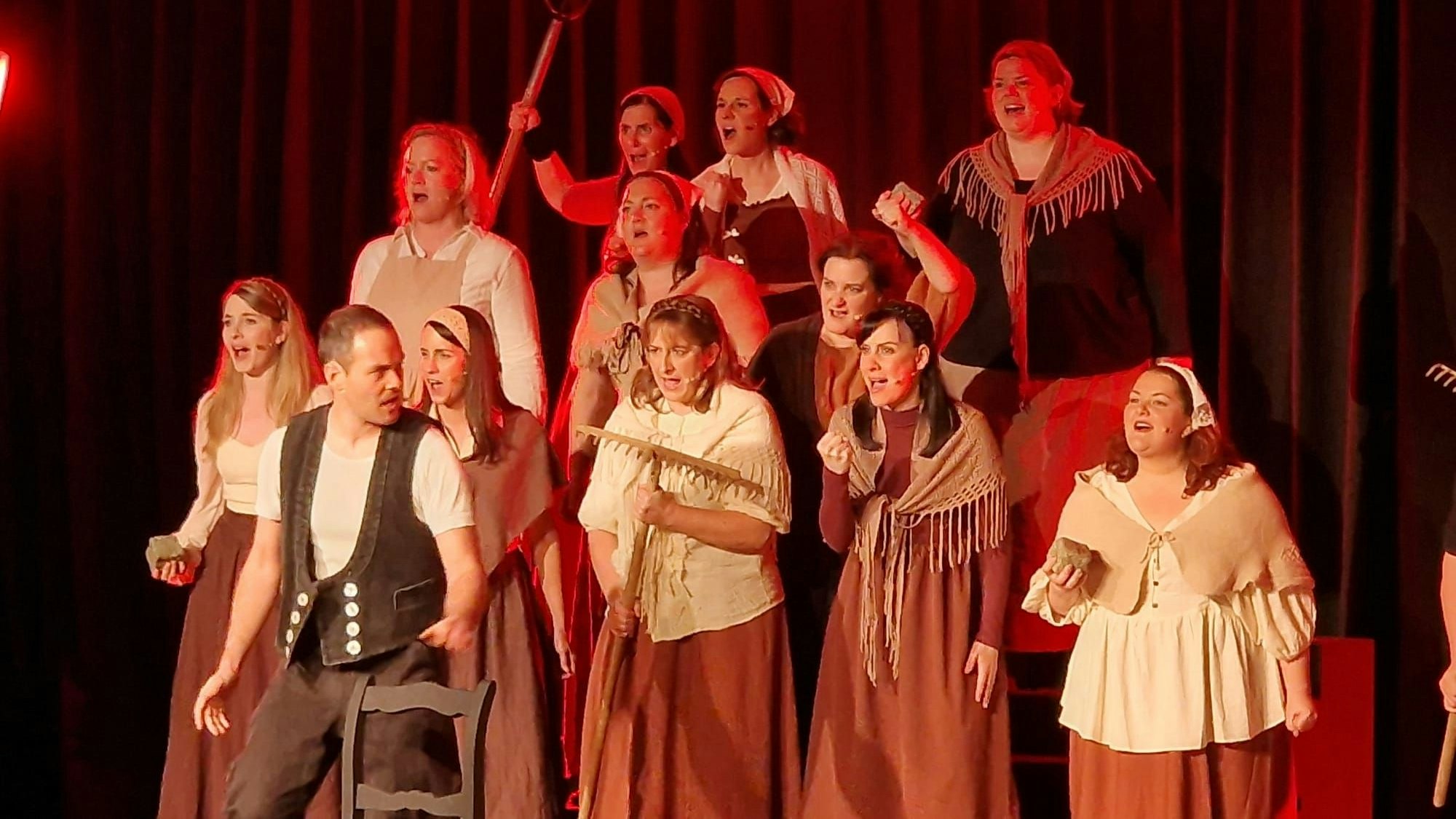 Auf der Bühne stehen kostümierte, singende Darsteller.