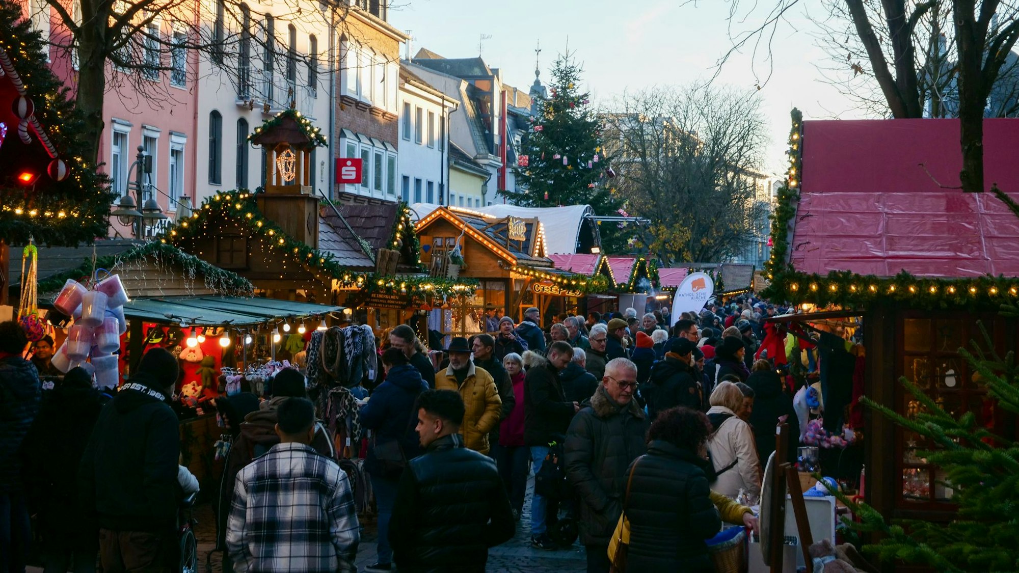 Zu sehen sind Menschen auf einem Weihnachtsmarkt.