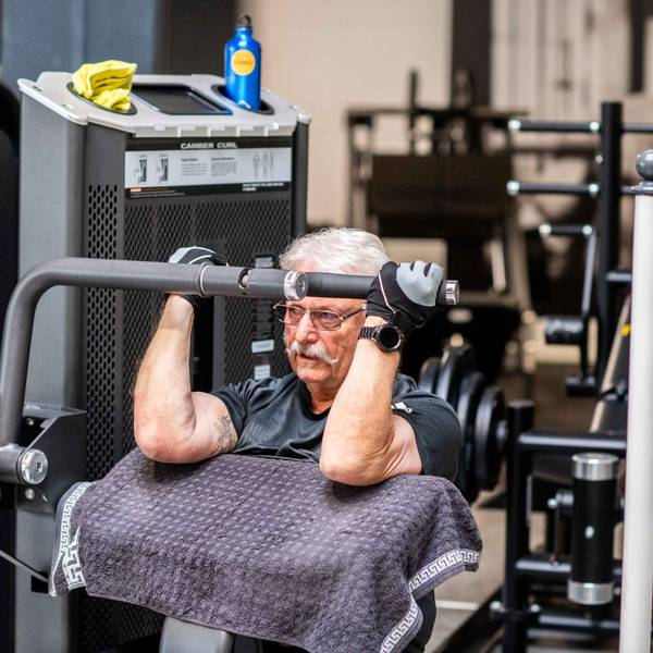 Das Bild zeigt Peter aus Wünschheim auf einem Sportgerät, mit dem man seinen Bizeps trainiert.