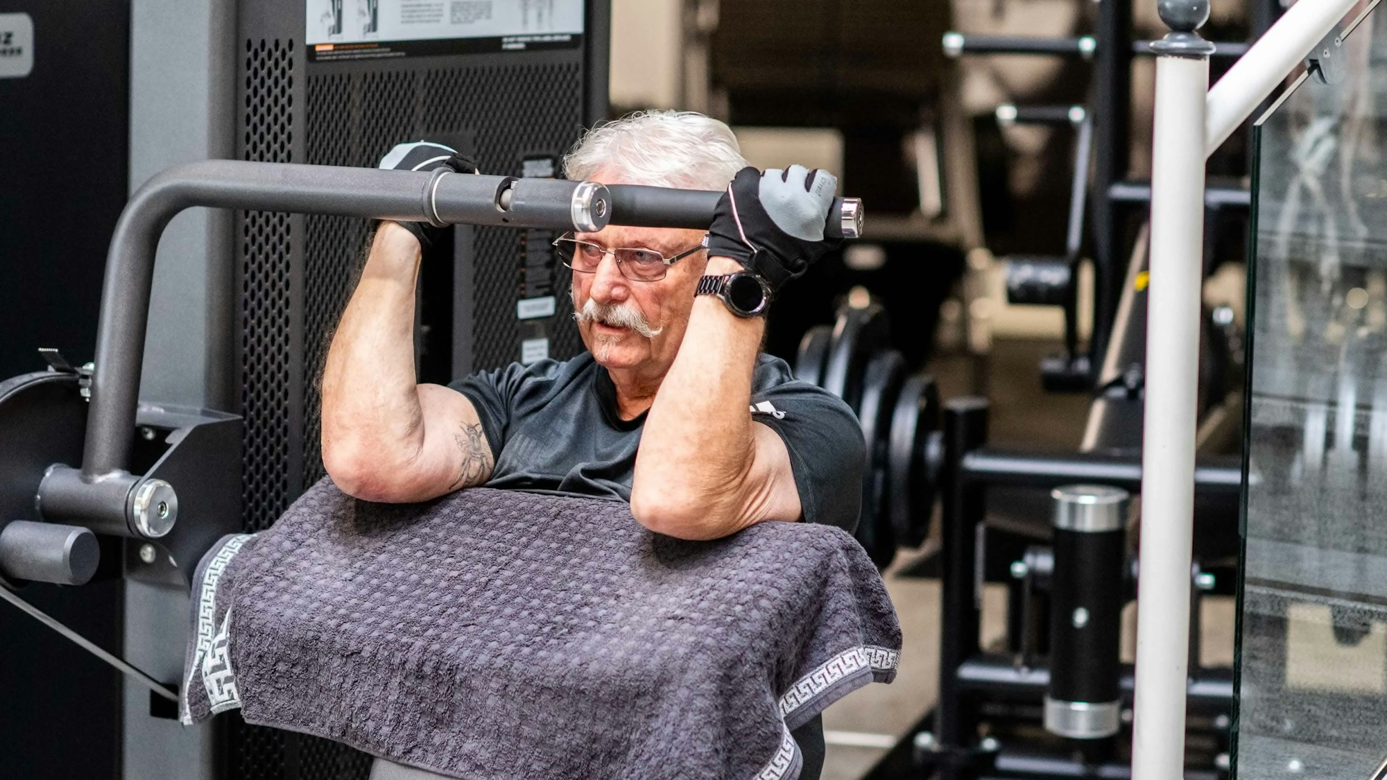 Das Bild zeigt Peter aus Wünschheim auf einem Sportgerät, mit dem man seinen Bizeps trainiert.