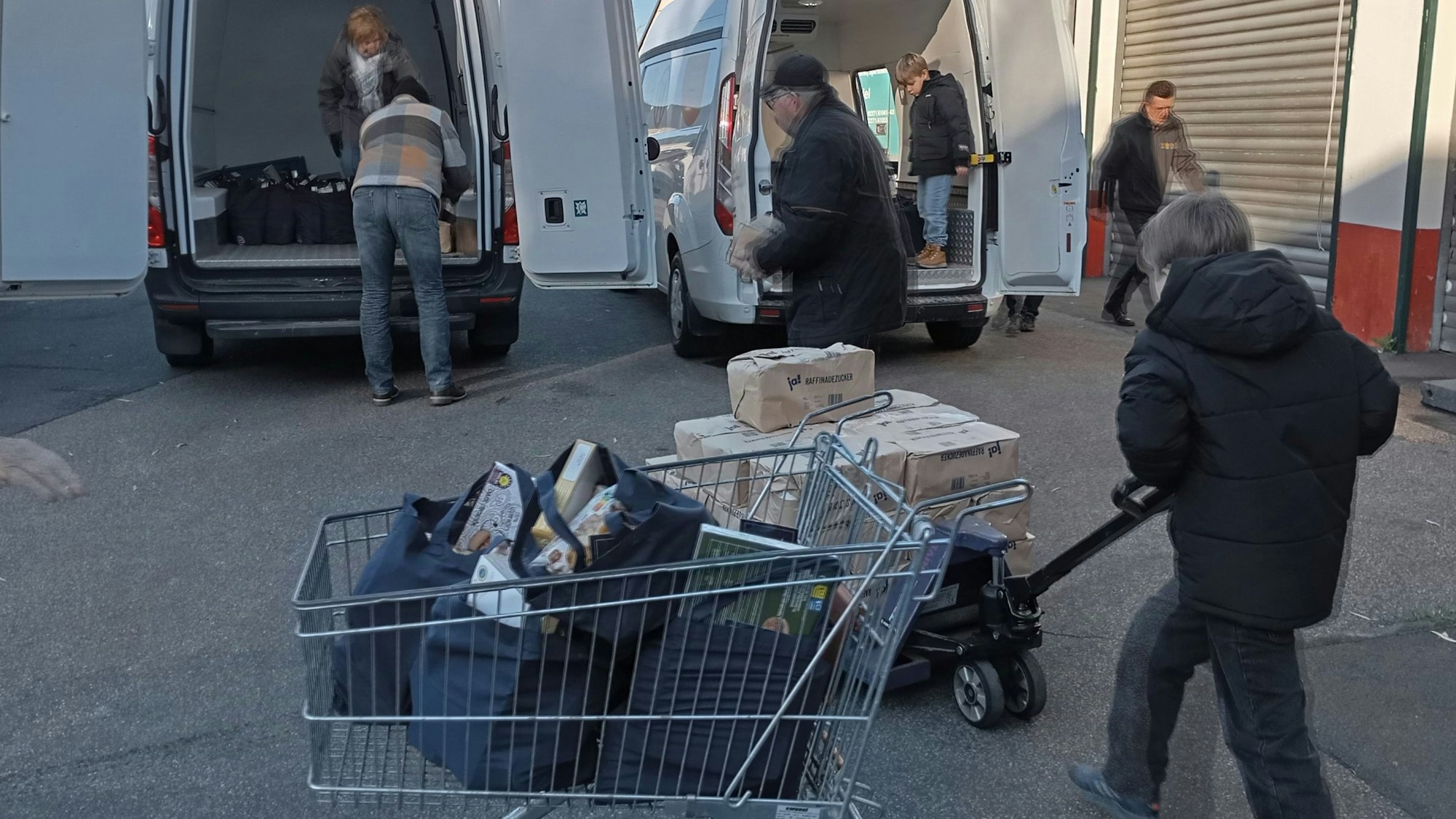 Helfer verladen Pakete in Lieferwagen.