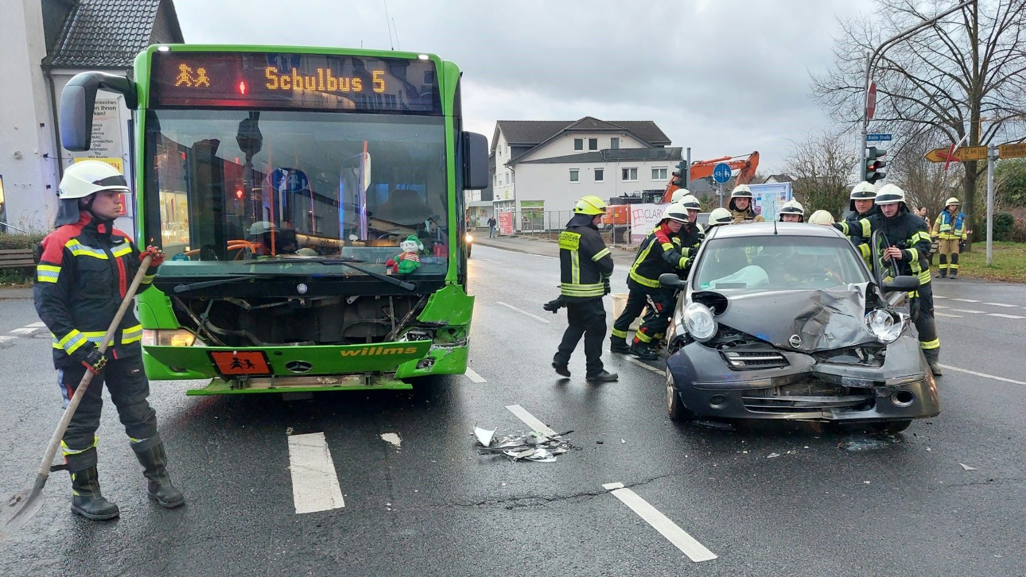 Ein beschädigter Linienbus und ein beschädigter Pkw auf einer Straße.