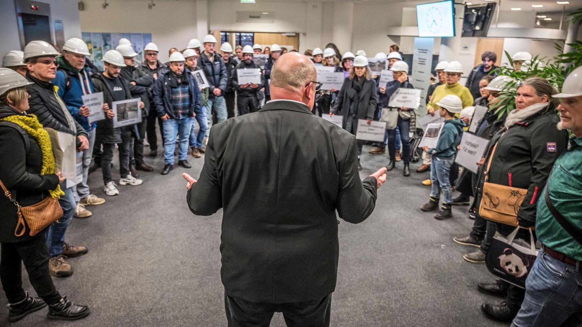 Stefan Hebbel im Kreise von Mitarbeitern, die gegen die Übernahme von Bau-Projekten durch die SWM (Stadtteilentwicklungsgesellschaft Wiesdorf-Manfort) protestieren. Foto: Ralf Krieger.