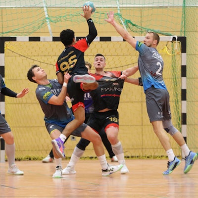 Zwei Abwehrspieler wollen Simsek am Wurf hindern, einer von ihnen hat gleichzeitig Kreisläufer Mayer am Trikot gepackt.