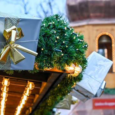 ARCHIV - 27.11.2023, Berlin: Auf dem Weihnachtsmarkt am Schloss Charlottenburg hängen Geschenkpakete an einem Verkaufsstand. (zu dpa: «Gebrauchte Weihnachtsgeschenke liegen im Trend») Foto: Jens Kalaene/dpa +++ dpa-Bildfunk +++