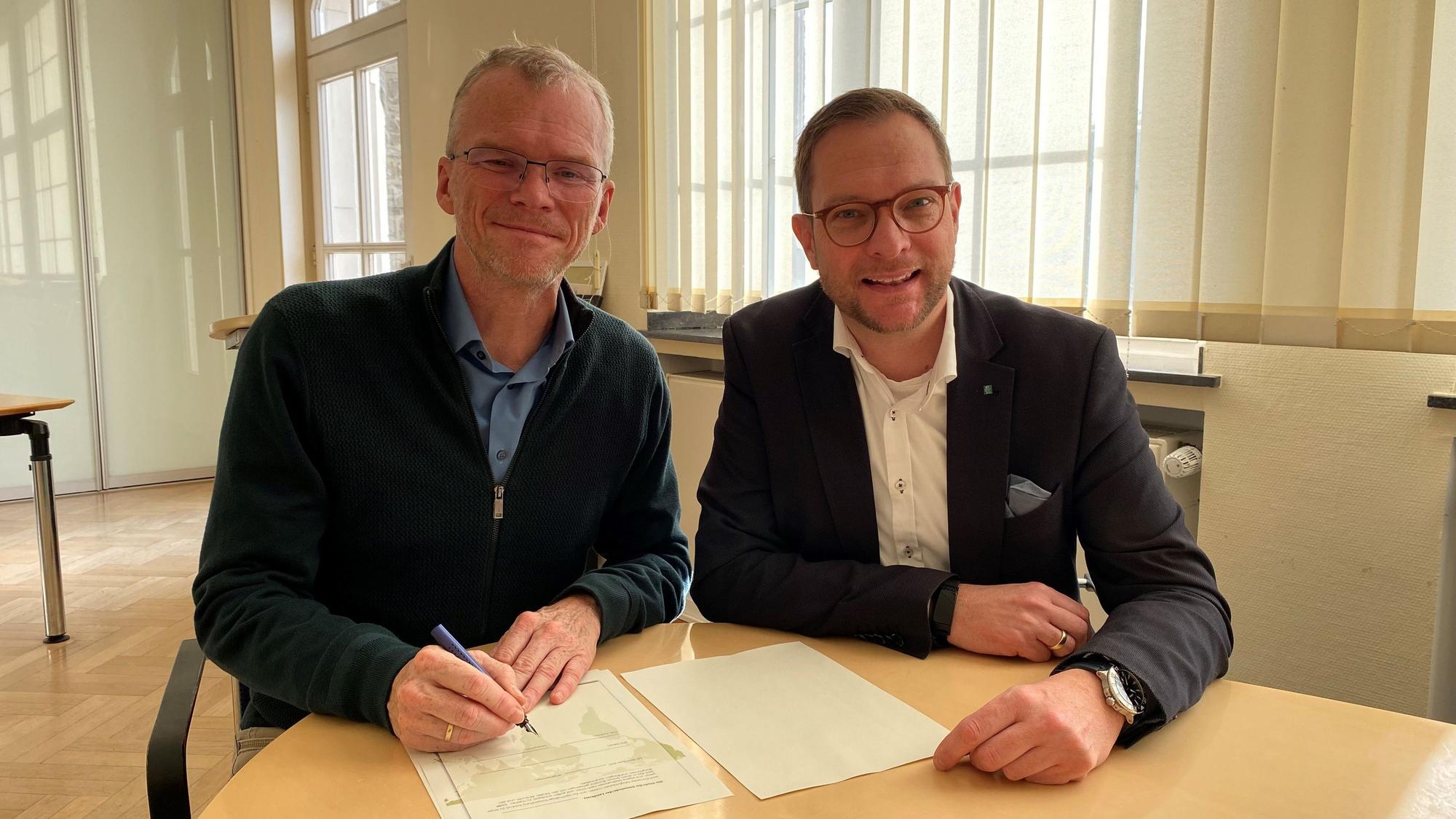 Bürgermeister Frank Stein (SPD) (links) unterschreibt zusammen mit Kämmerer Thore Eggert (FDP) die Musterresolution.