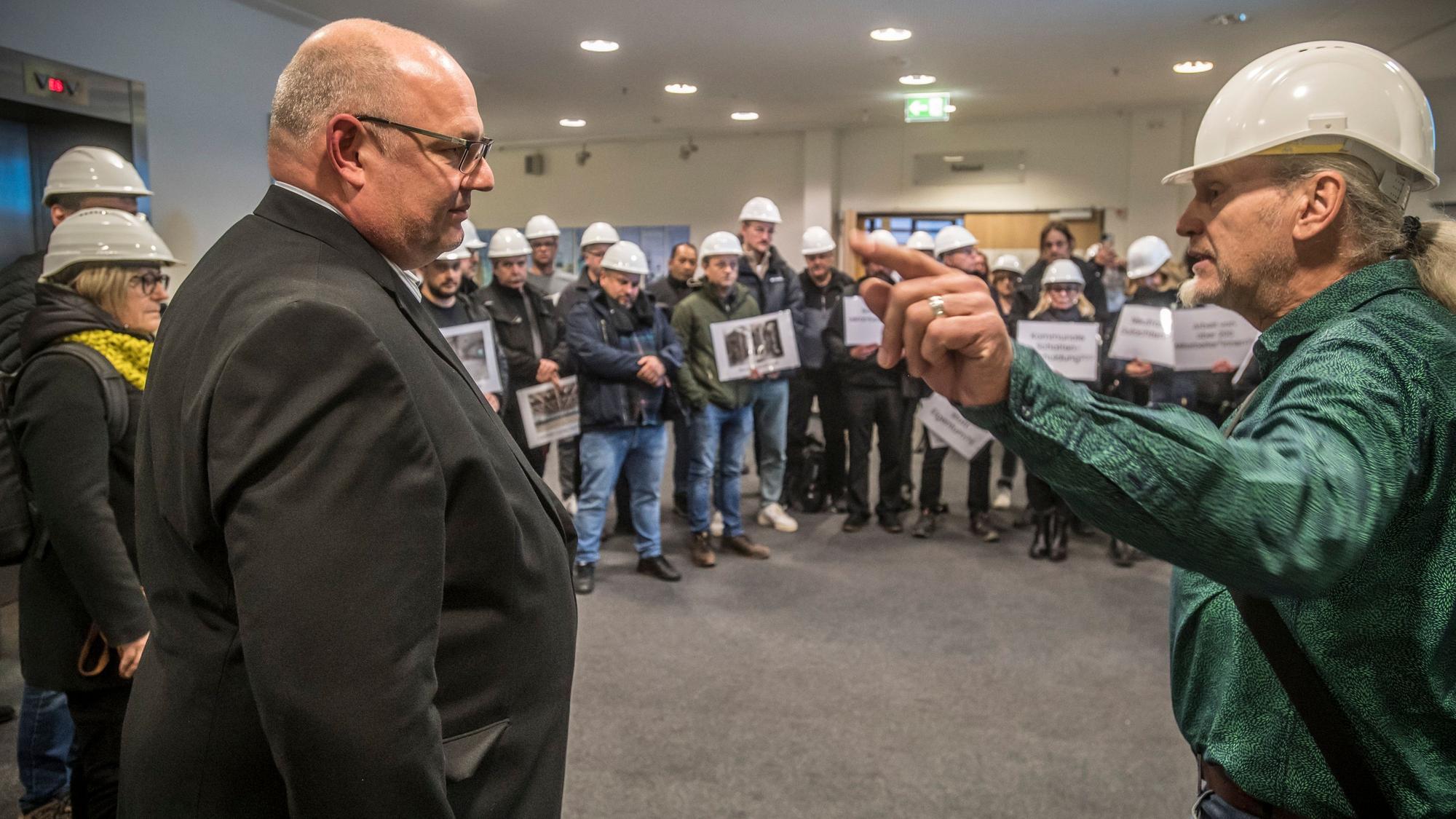 Stefan Hebbel im Kreise von Mitarbeitern, die gegen die Übernahme von Bau-Projekten durch die SWM (Stadtteilentwicklungsgesellschaft Wiesdorf-Manfort) protestieren. Rechts Andreas Blumenthal Foto: Ralf Krieger.