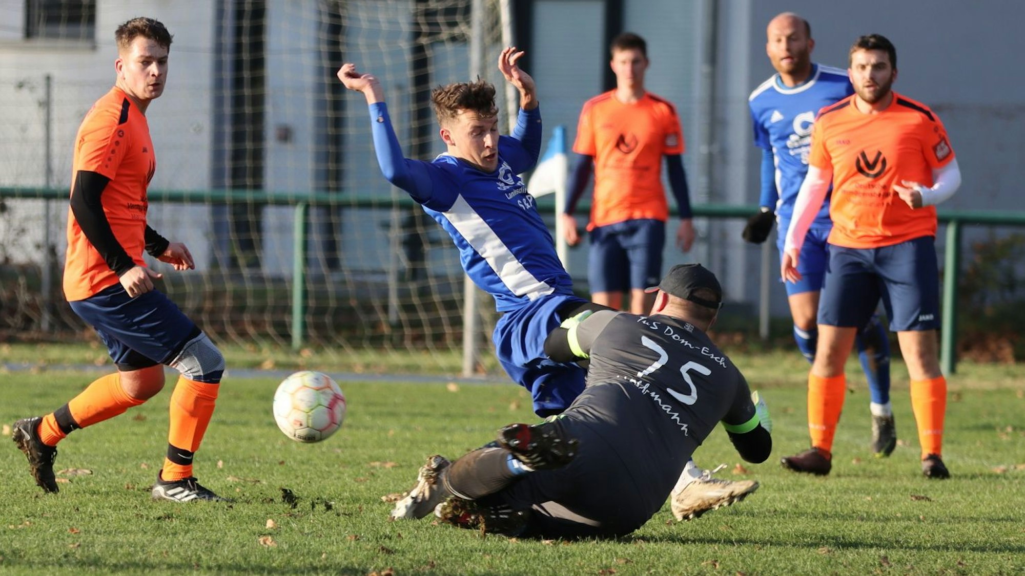 Das Bild zeigt einen Zweikampf im Strafraum des TuS Dom-Esch. TuS-Schlussmann Lewis Hoffmann rettet.