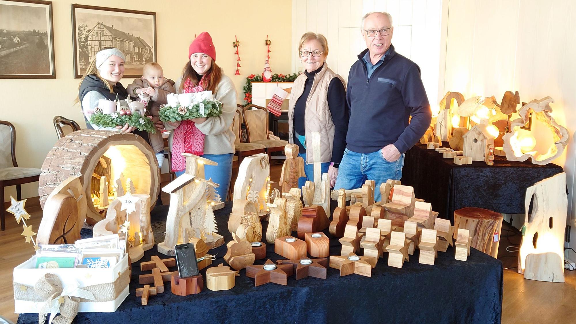 Die genannten Personen zeigen Adventskränze und Holzobjekte.
