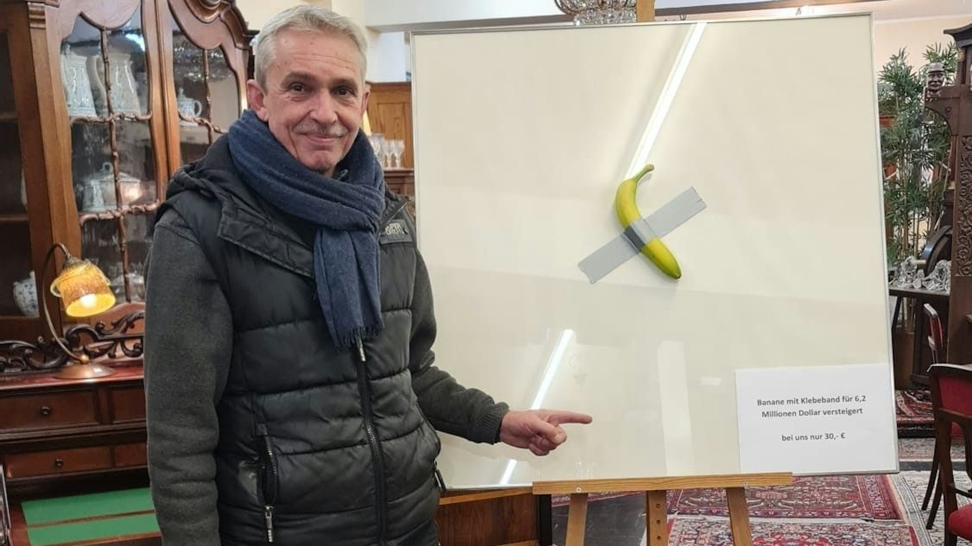 Ralf Bree zeigt seine kölsche Interpretation des Bananen-Kunstwerks in seinem „Antik-Shop“.
