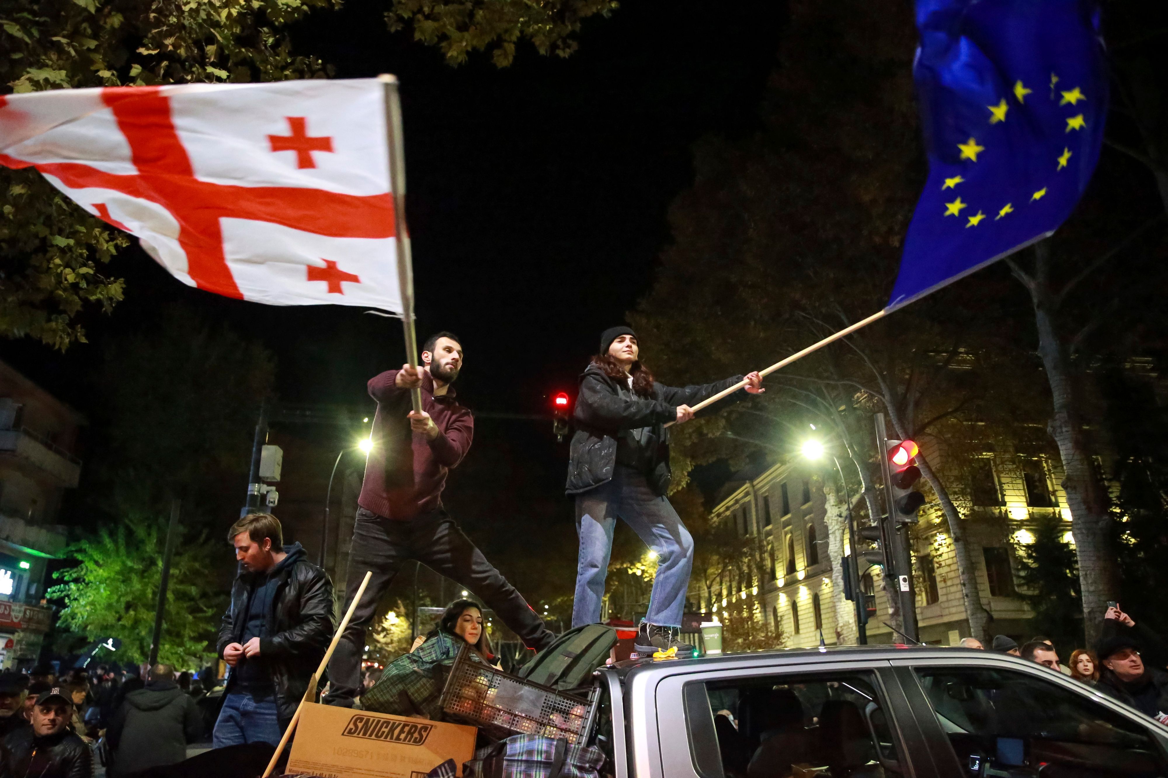 Während einer Kundgebung schwenken Demonstrierende die Flaggen der EU und Georgiens. (Archivbild vom 17.11.2024)