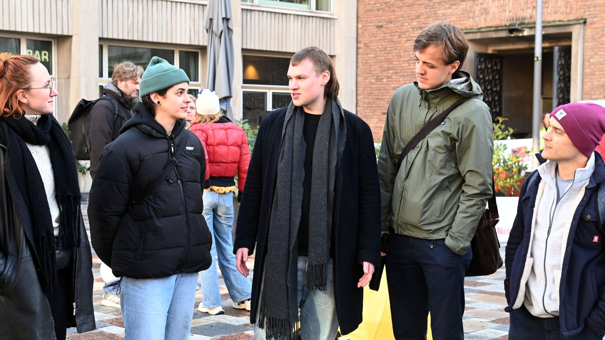 Konrad Schmitz steht mit einer Gruppe auf einem Platz und unterhält sich.