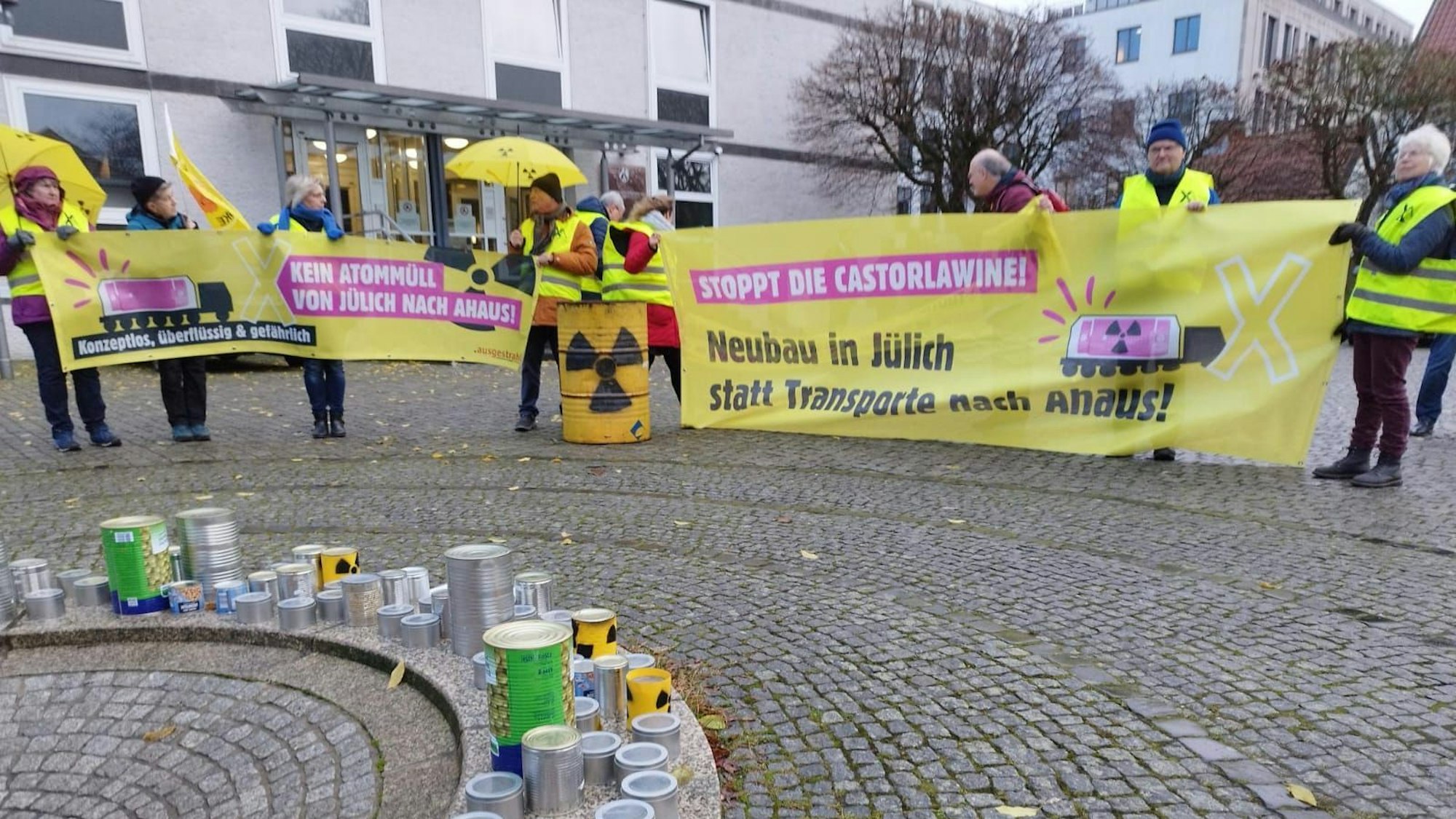 Protestler stehen mit Bannern vor dem OVG Münster.