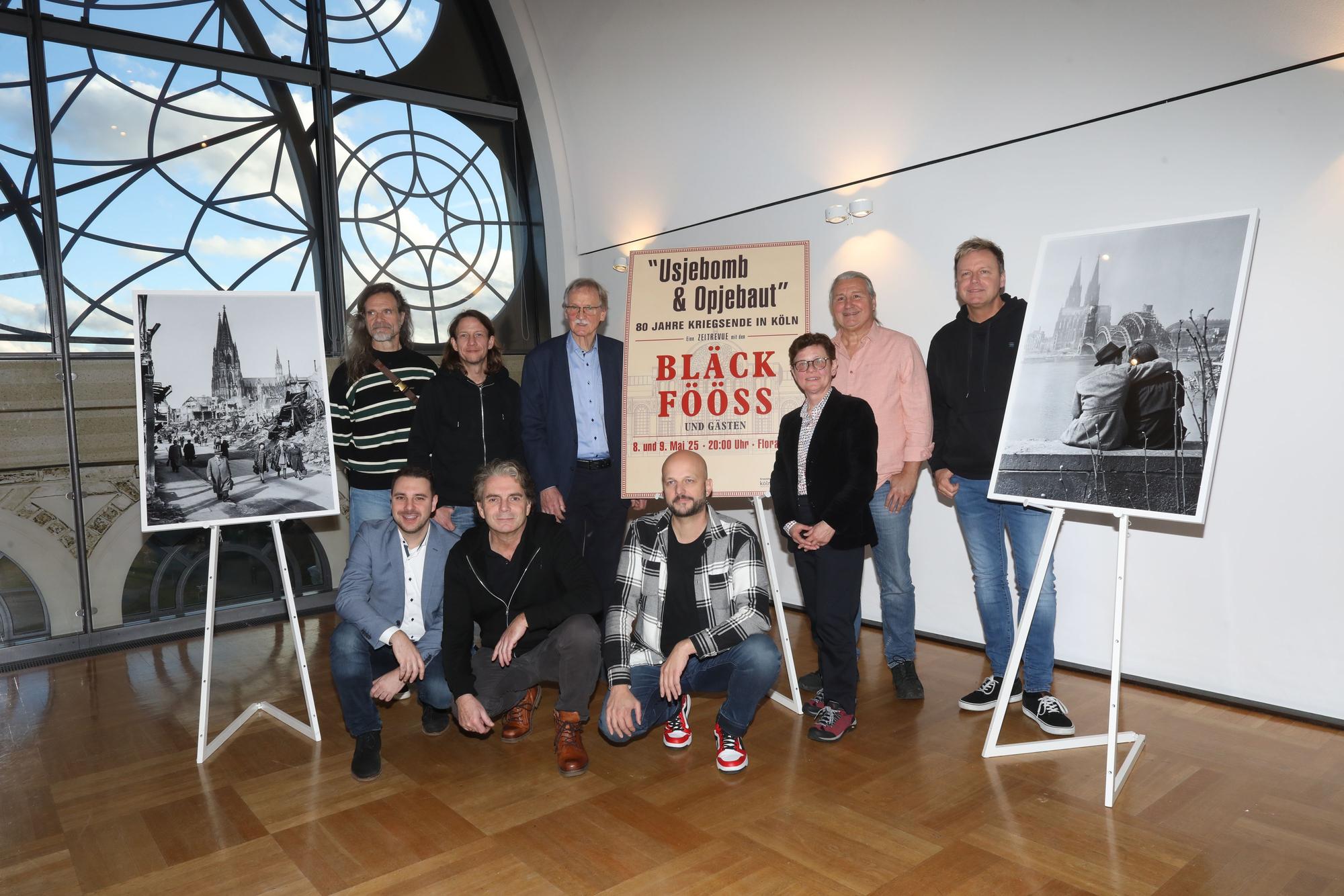 Mitglieder der Bläck Fööss neben Plakaten für eine geplante Revue in der Flora