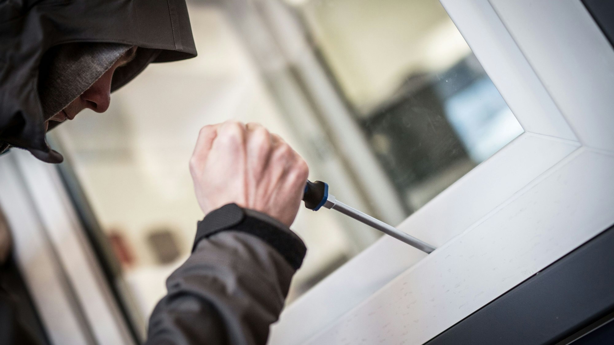 Ein Mann demonstriert in der polizeilichen Beratungsstelle, wie Einbrecher Fenster aufhebeln.