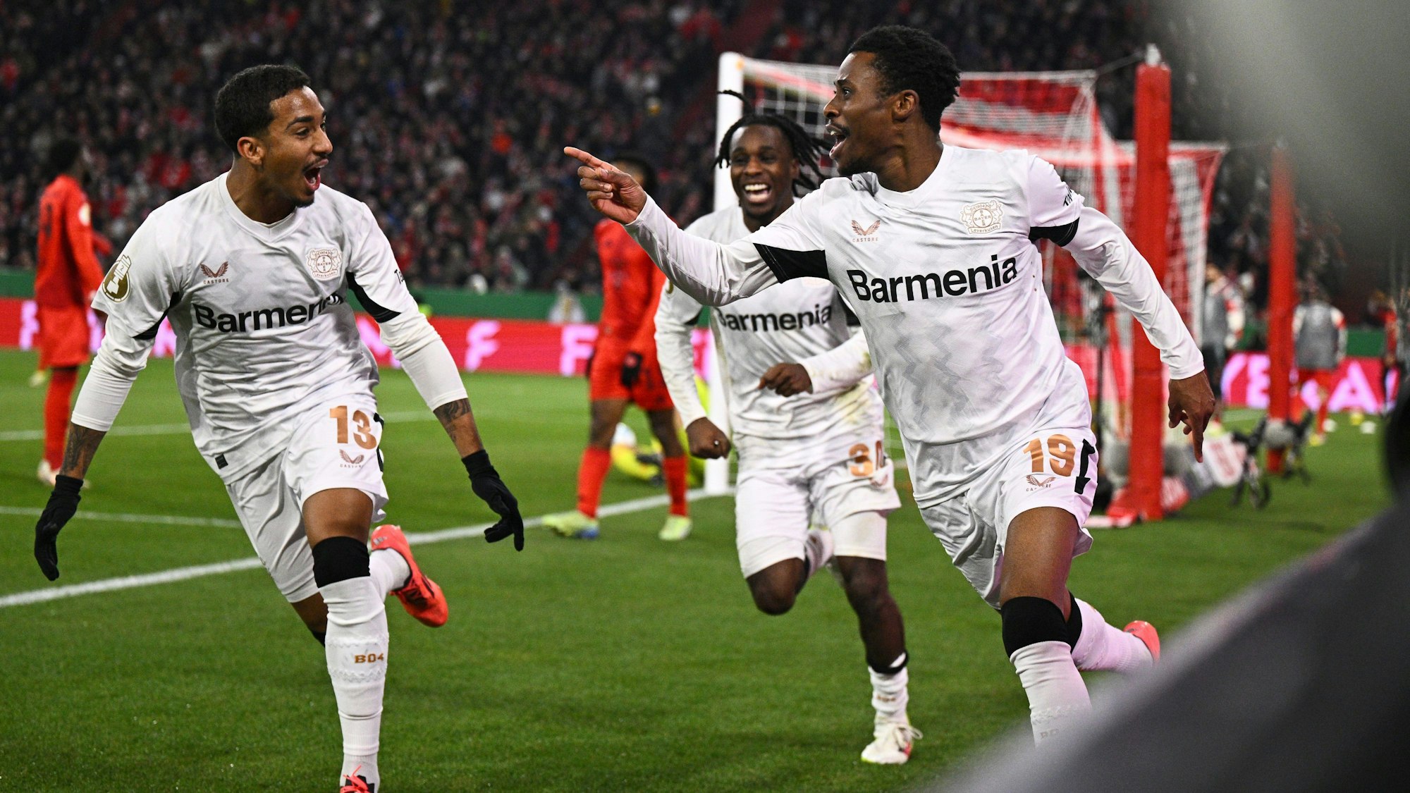 Leverkusens Nathan Tella (r) bejubelt sein Tor zum 1:0 im Pokalspiel beim FC Bayern.