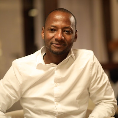 Wie Alhassane Barry aus Guinea einen Job fand und so in Deutschland ankam: Ein Porträt von Barry im weißen Hemd.