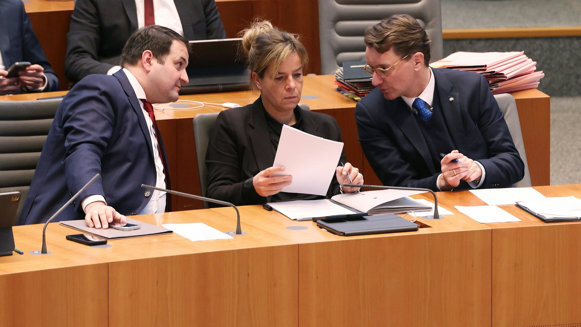 Europaminister Nathanael Liminski (CDU), Wirtschaftsministerin Mona Neubaur (Grüne) und Ministerpräsident Hendrik Wüst (CDU) während der Plenarsitzung des Landtags in Düsseldorf.