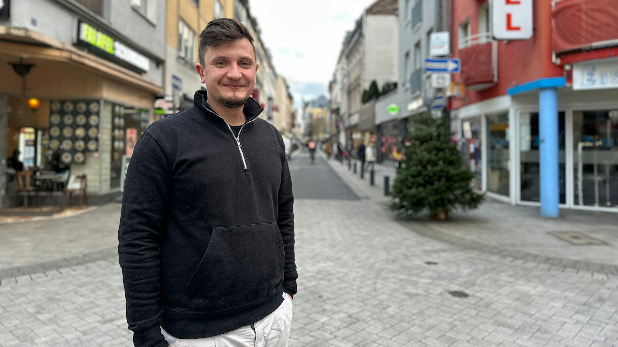 Ein junger Mann steht er auf der Severinstraße in Köln