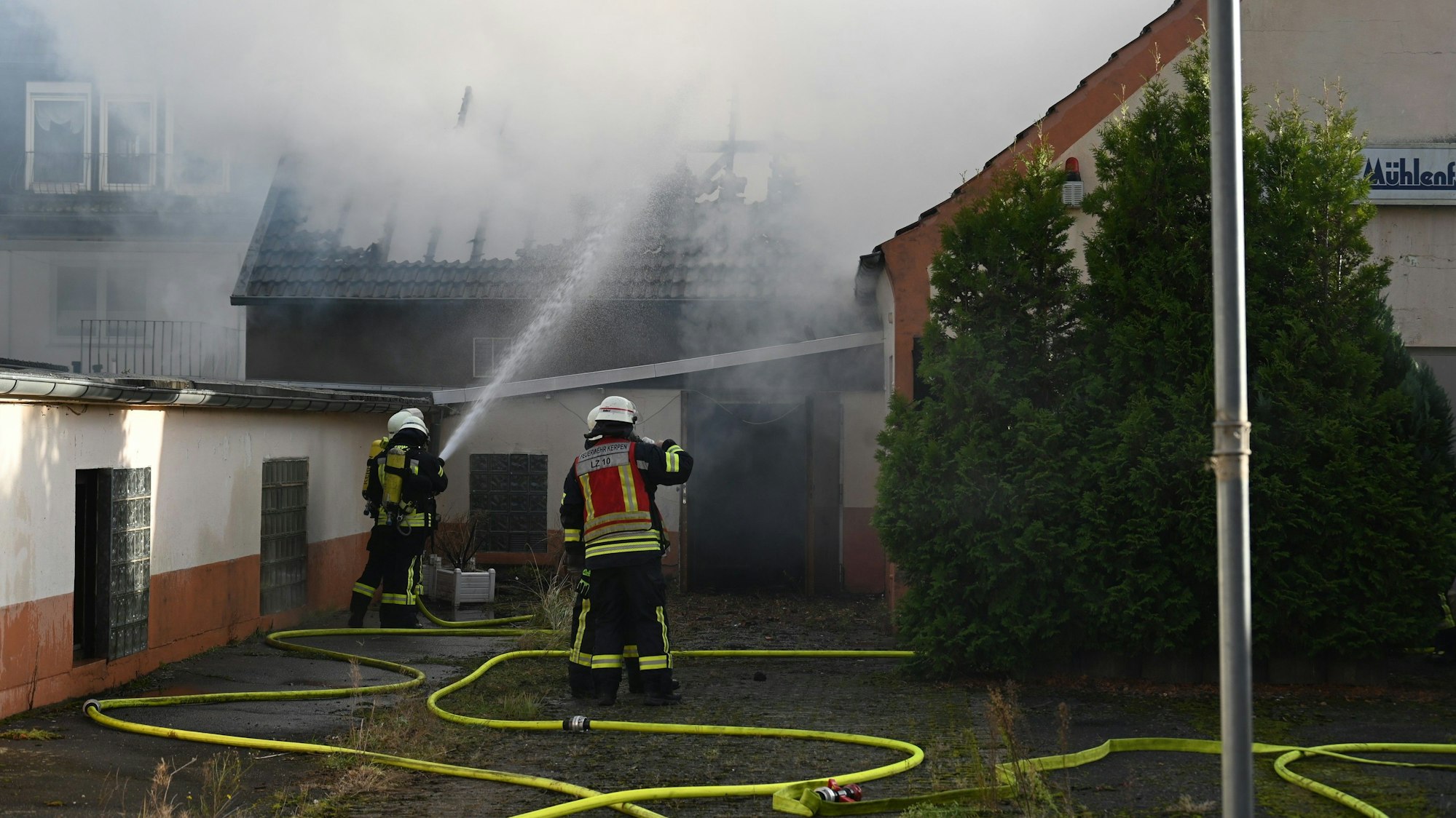Das Foto zeigt Feuerwehrleute, die das Feuer löschen. Der Dachstuhl ist schon komplett abgebrannt.