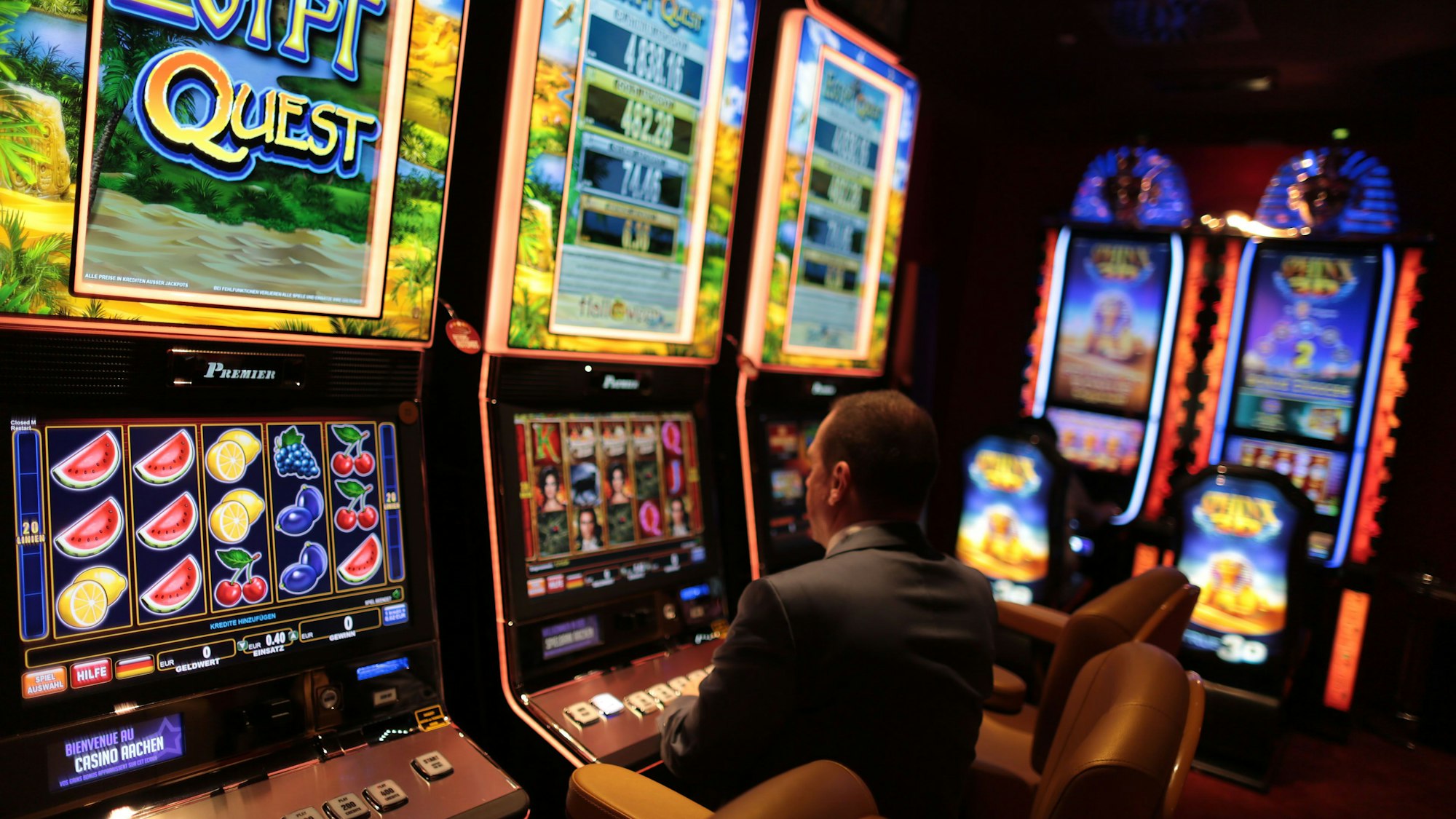 Besucher eines Spielcasinos sitzt vor einem Spielautomaten