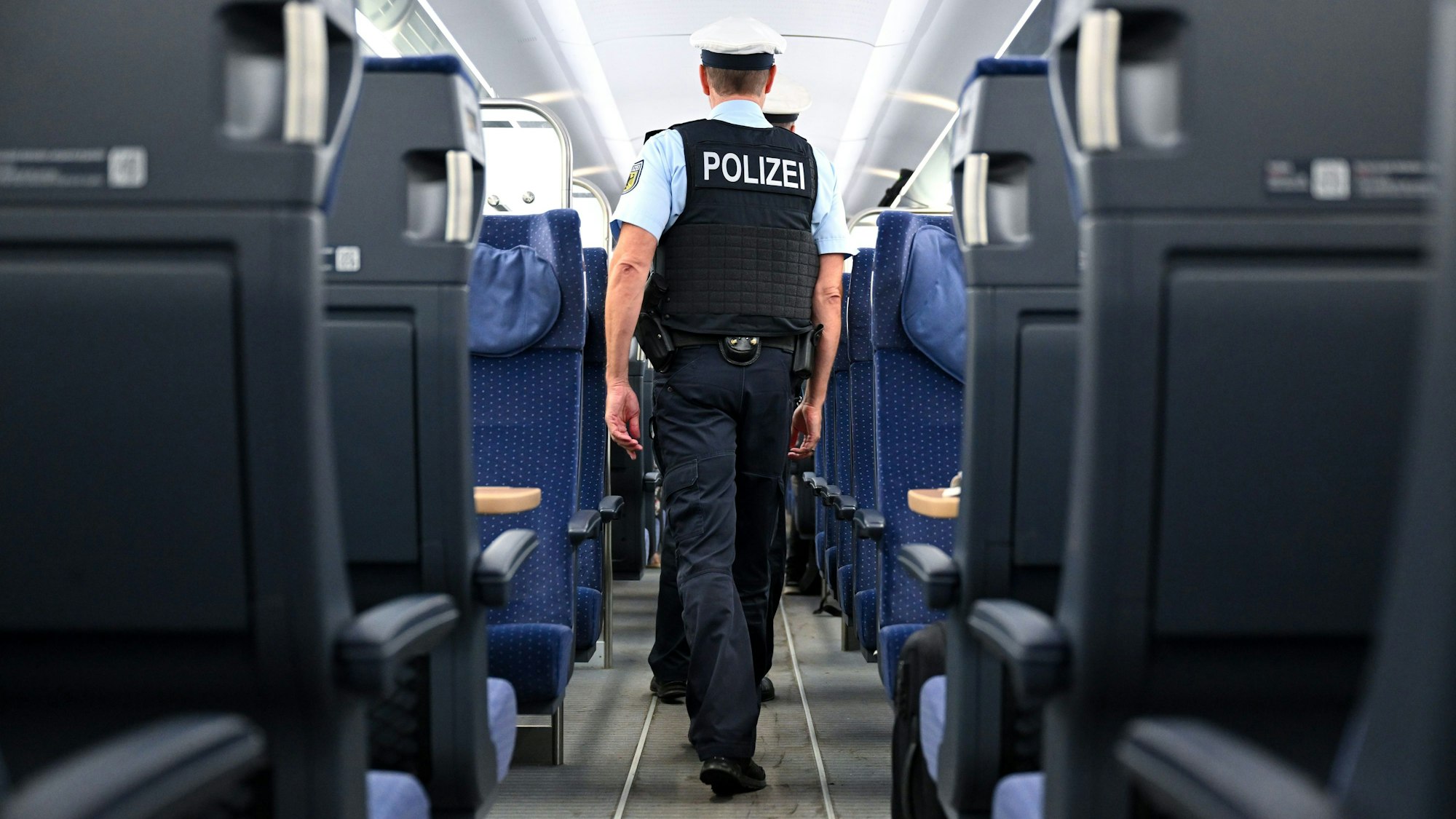 Bundespolizisten gehen durch einen ICE der Deutschen Bahn
