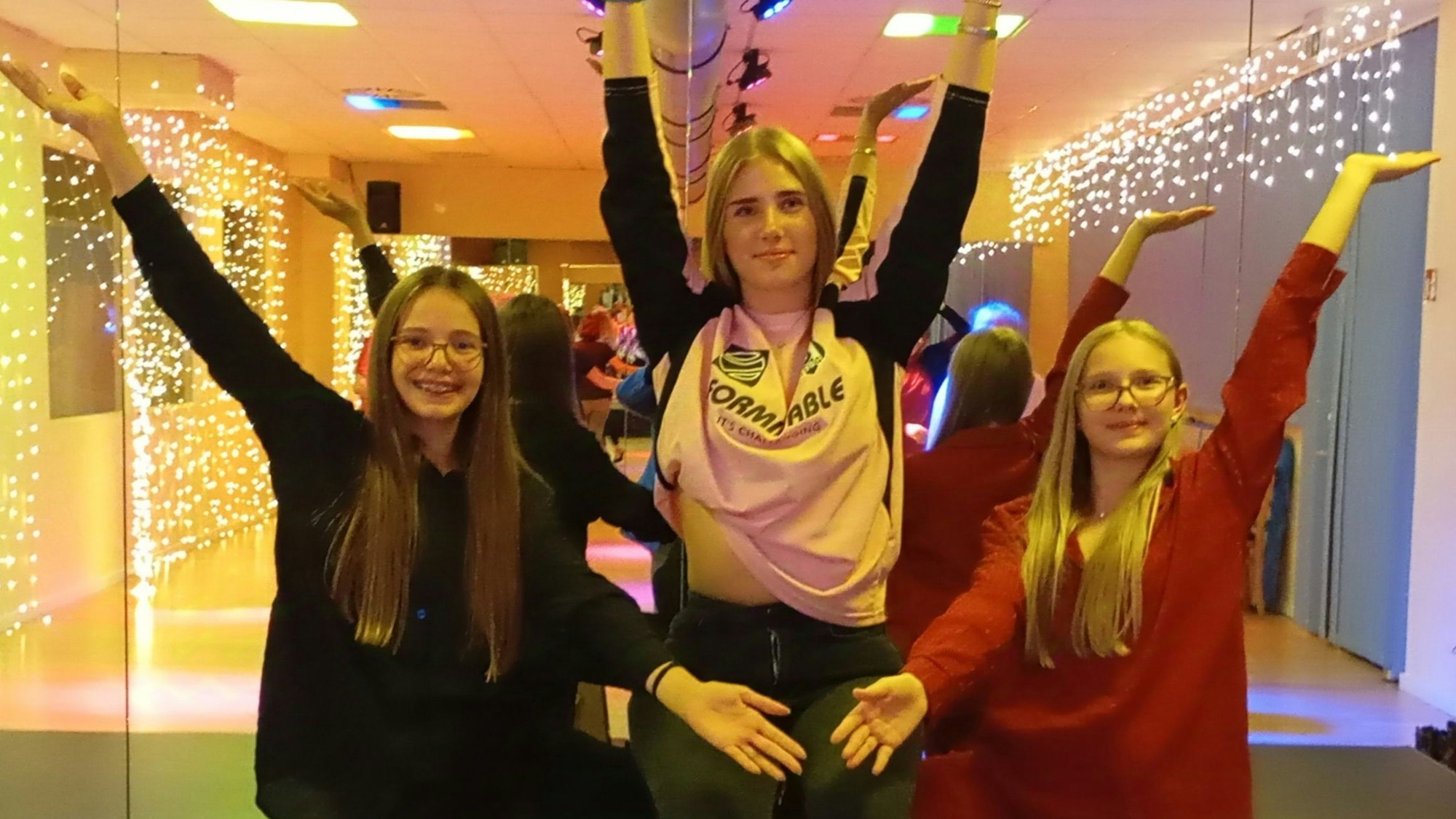 Auf dem Bild sind drei Tänzerinnen zu sehen, die eine gemeinsame Siegerpose machen.